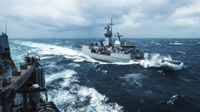 Royal Australian Navy frigate HMAS Parramatta encountering rough ocean conditions.