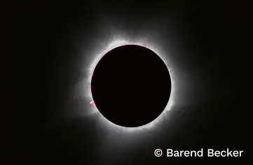 Solar eclipse. A rim of light from the sun halos the dark moon in a black sky.